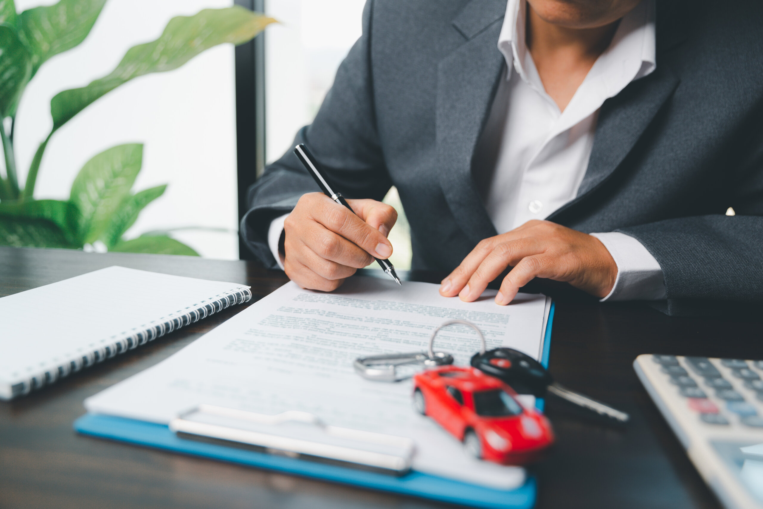 man signing auto insurance agreement