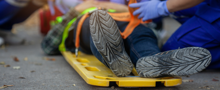 Injured person lying on a stretcher being attended by emergency responders in North Dakota, related to personal injury attorney