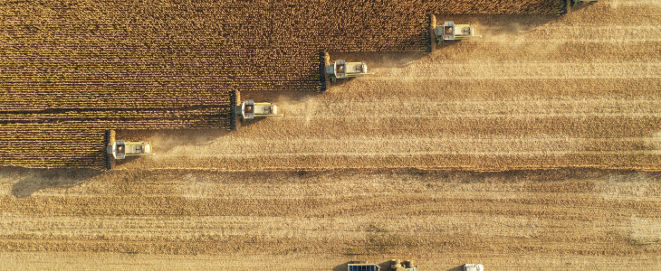 Aerial view of multiple combines harvesting a large field in North Dakota, related to personal injury attorney