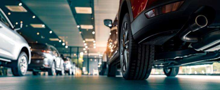 Row of cars inside a dealership showroom with bright lighting in North Dakota, related to personal injury attorney